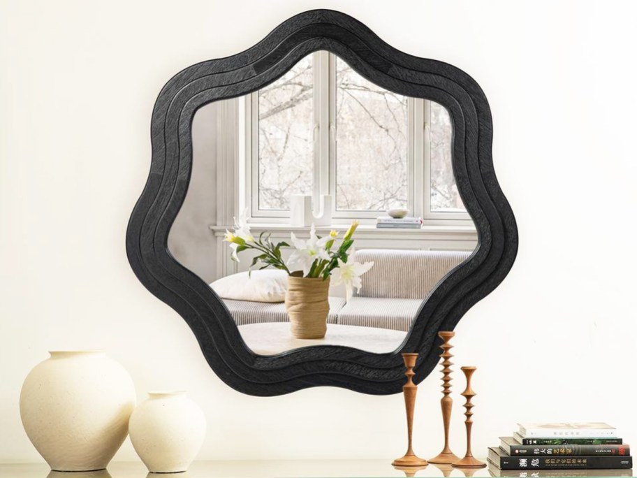 black wavy shaped mirror on a wall