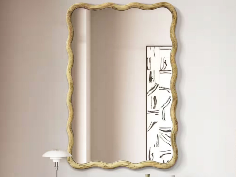 wavy wood framed mirror on a wall
