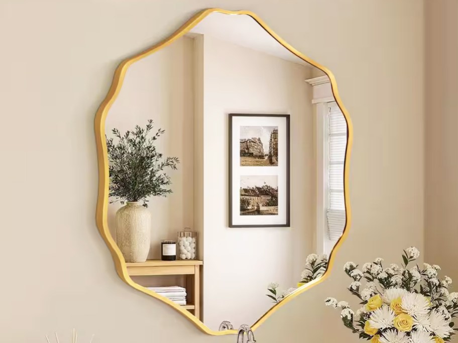 gold framed scalloped mirror on bathroom wall