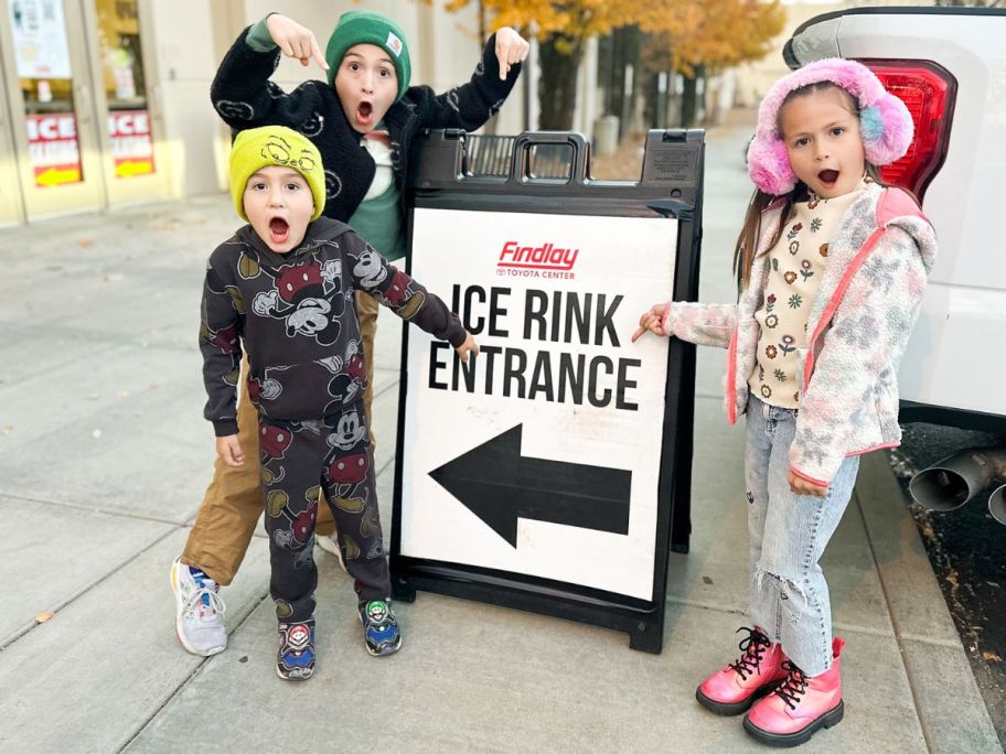 children holding Ice rink door sign