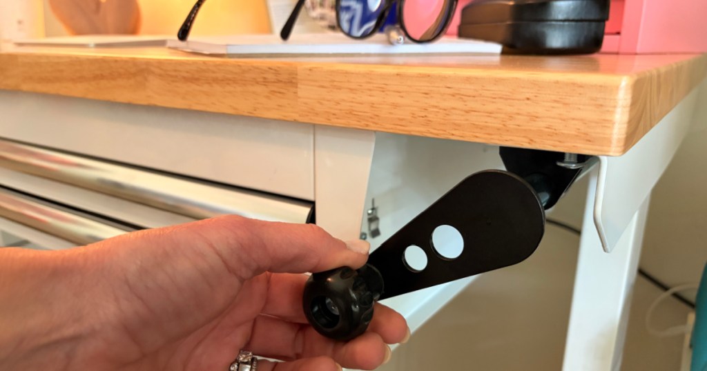 Hand turning black handle of kobalt workbench