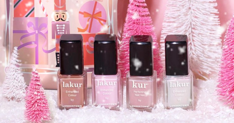 4 bottles of nail polish near pink bottle brush trees