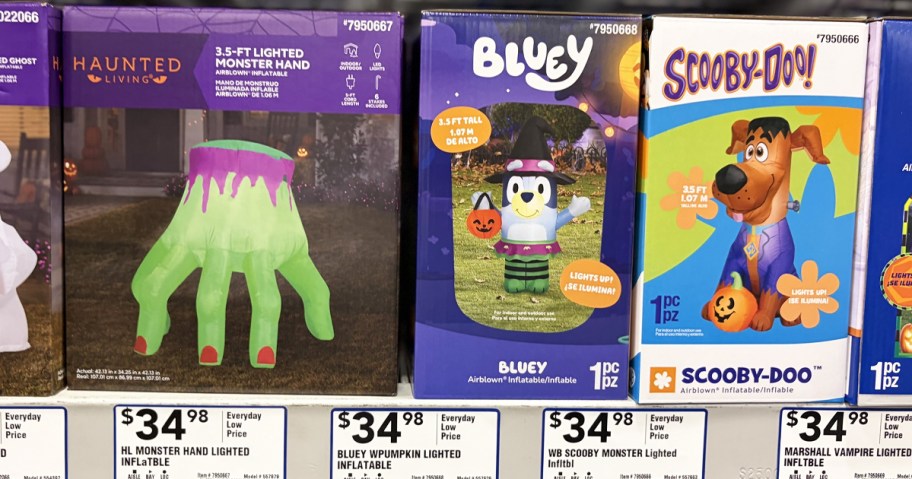 monster hand, bluey, and scooby-doo halloween inflatable boxes on shelf