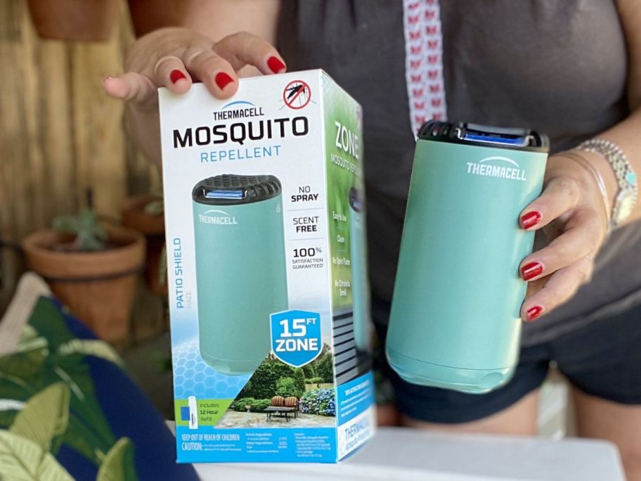 woman holding mosquito repellent in blue showing it off