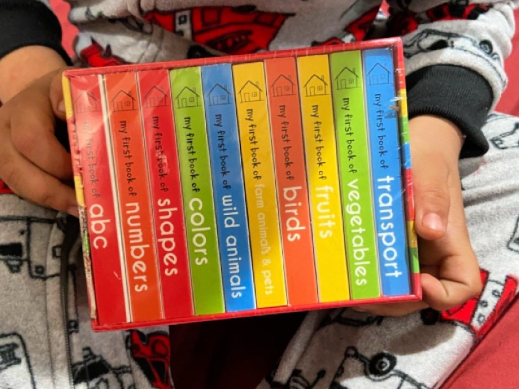 little kid holding My First Library Boxset 10 Board Books