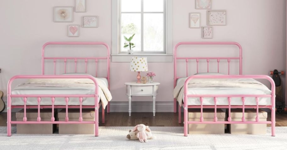 two pink twin side beds displayed in a bedroom