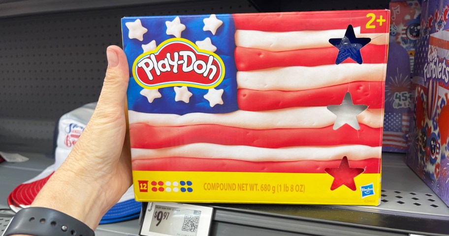 hand holding a red white & blue pack of play-doh