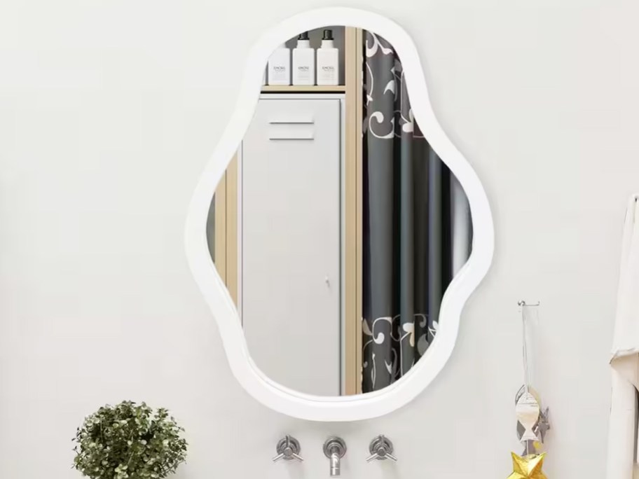 irregular wavy white wood framed mirror on a wall