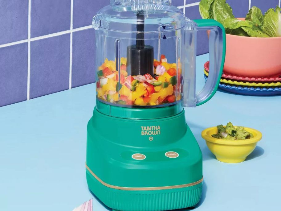 A teal mini chopper with peppers in it