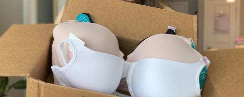 woman holding a box with vanity fair bras inside