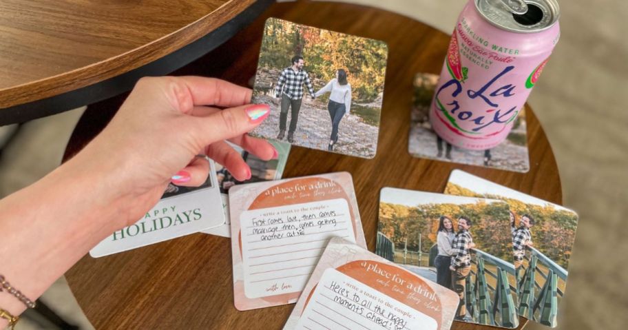 Hand holding a Walgreens coaster with other coasters around it and a can of La Croix set on one