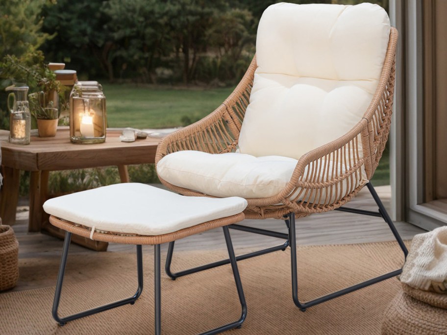 Cozy rattan chair with white cushions on a wooden deck, paired with a matching ottoman.