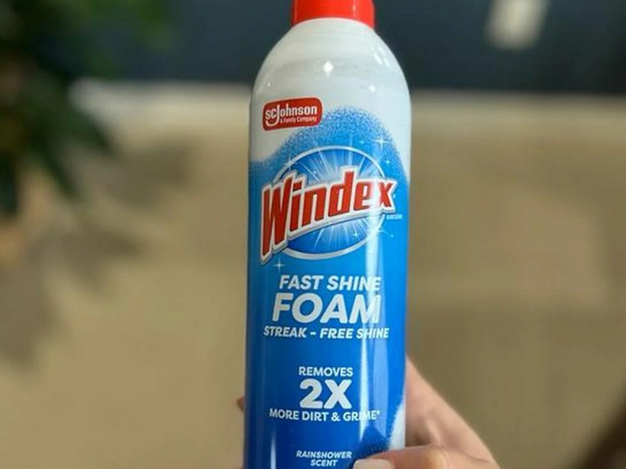person holding windex fast shine foam glass cleaner can