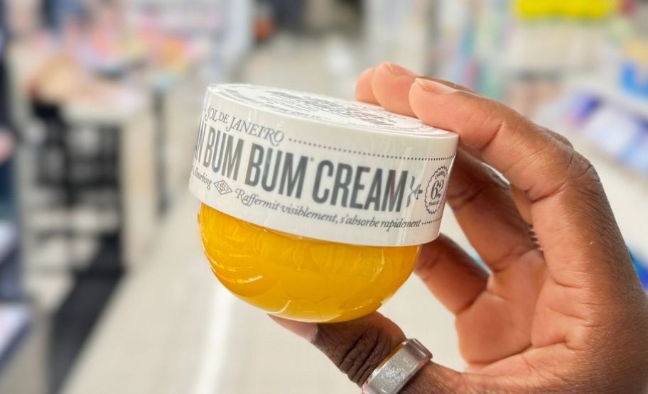 A hand holding bum bum cream