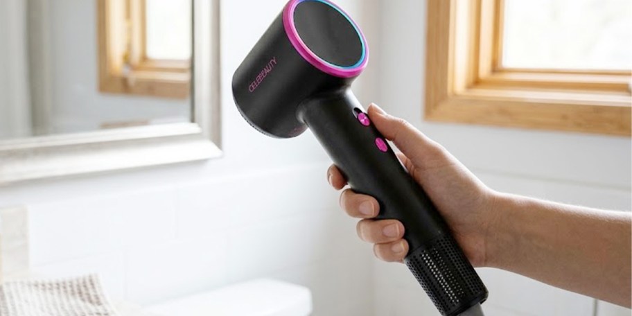 hand holding pink and black hair dryer 