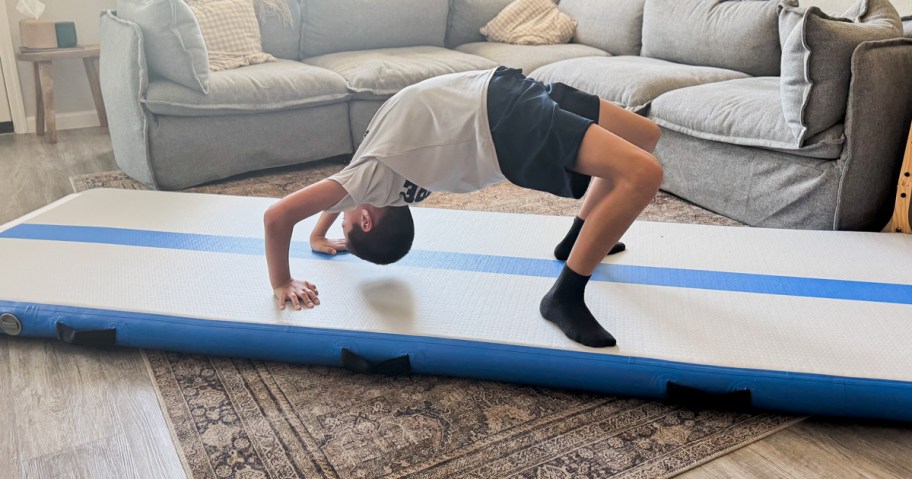 boy doing a backbend on a gymnastics mat