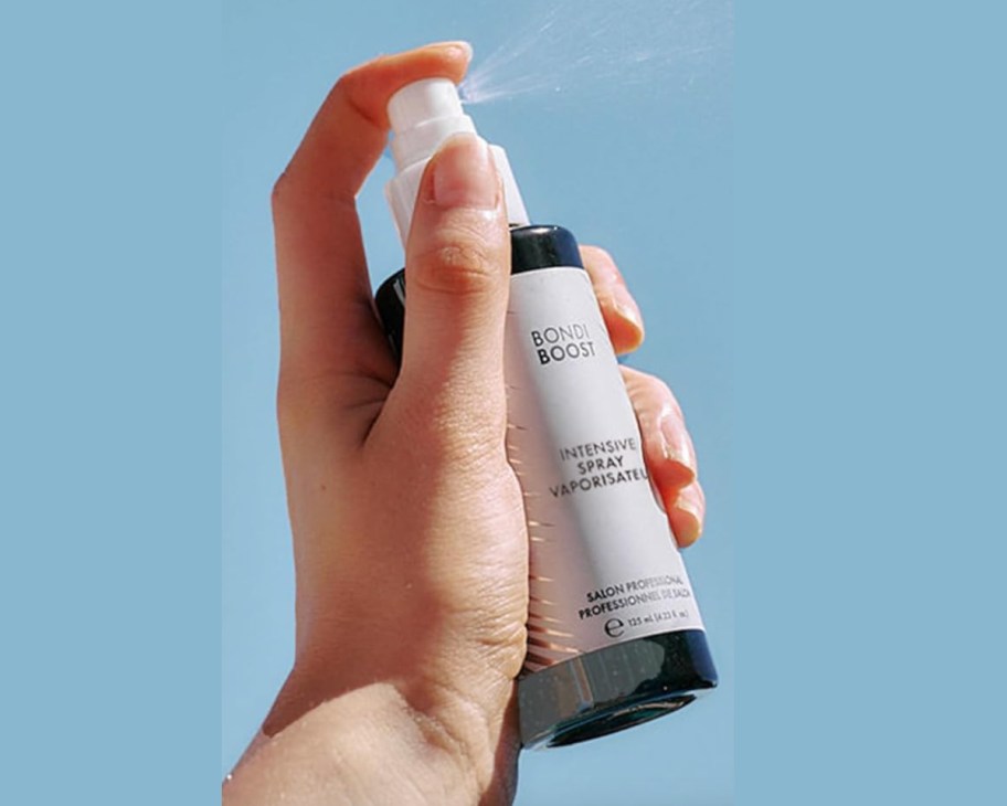 hand spraying mist into sky