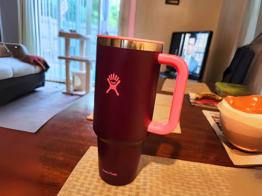 purple and pink hydro flask tumbler on table