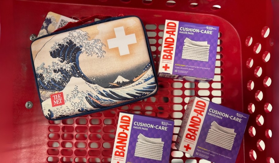 first aid kit in a shopping cart with 3. boxes of gauze pads 