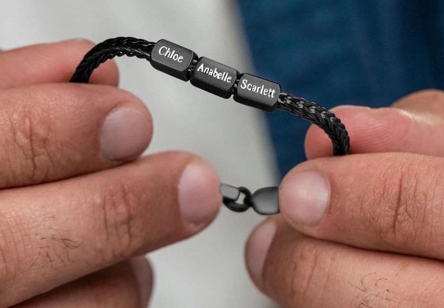 hands holding black personalized chain name bracelet