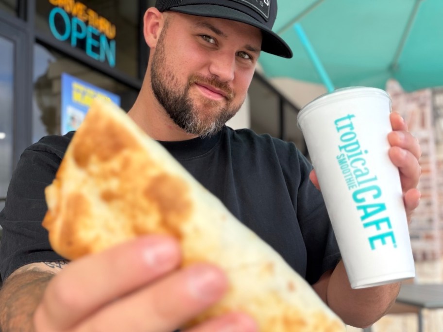 man holding smoothie and wrap