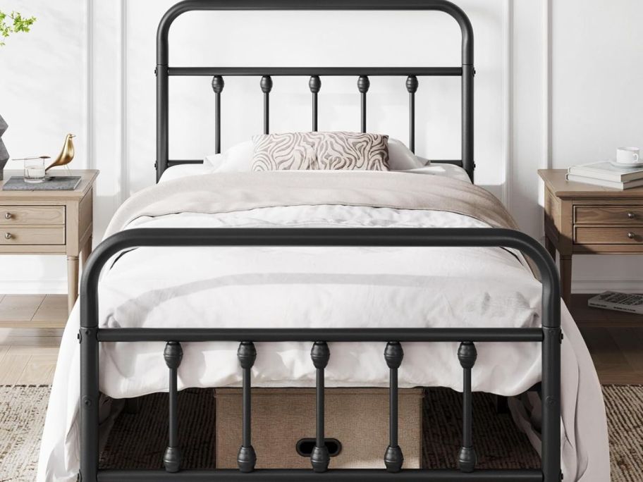 Twin black bed frame with white bedding 