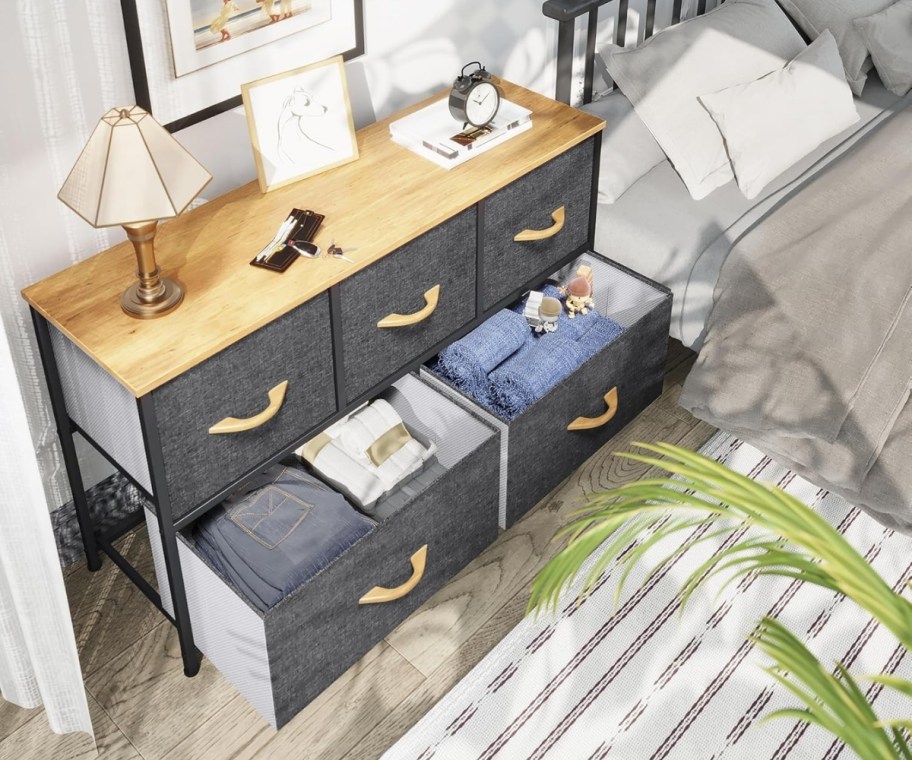 a five drawer dresser in a bedroom next to a bed