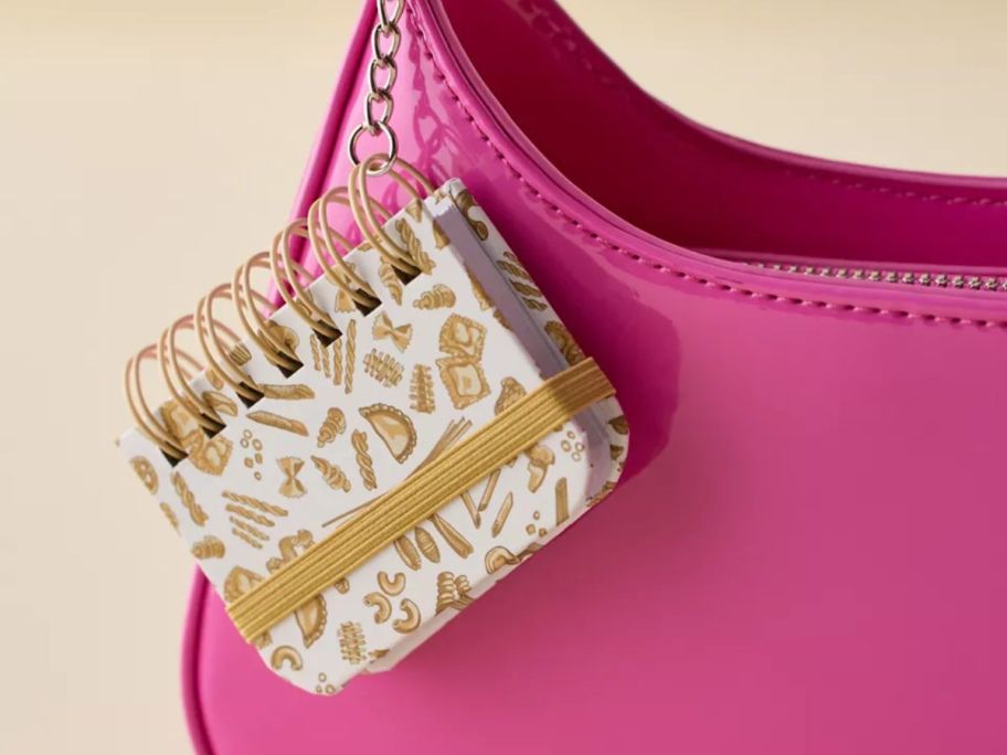 a mini spiral notebook keychain on a purse