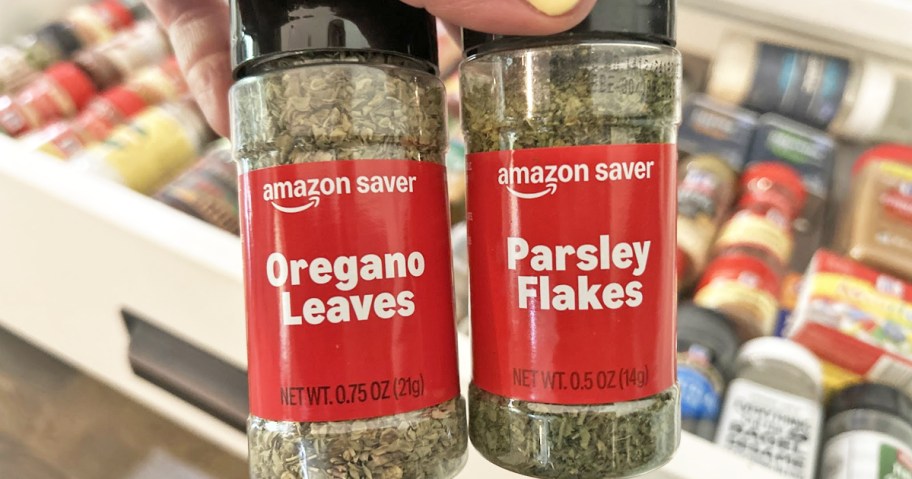 holding up bottles of amazon saver oregano and parsley spices