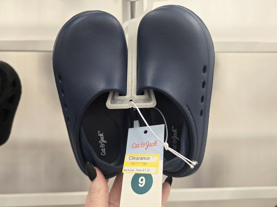 navy blue clogs hanging on store display with clearance tag