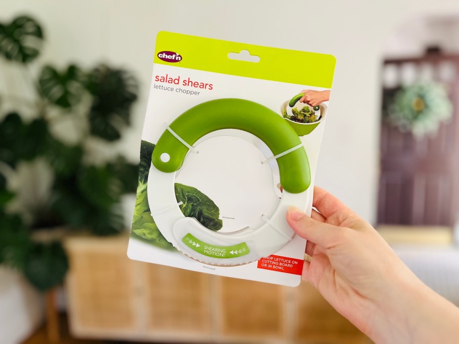 hand holding salad shears in air with packaging