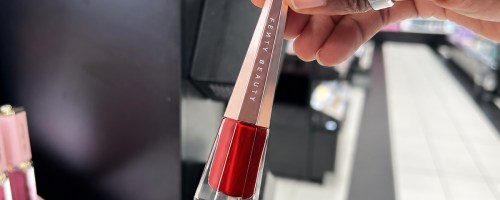 hand holding up a tube of red color in store