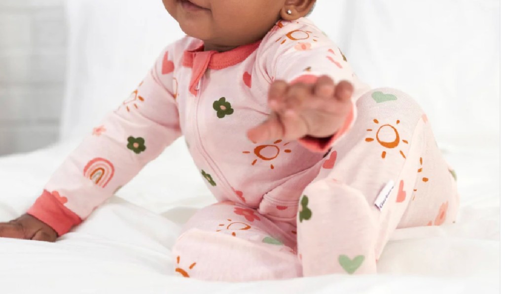 little baby wearing Gerber Baby Girls Sunshine & Rainbows Sleep 'N Play