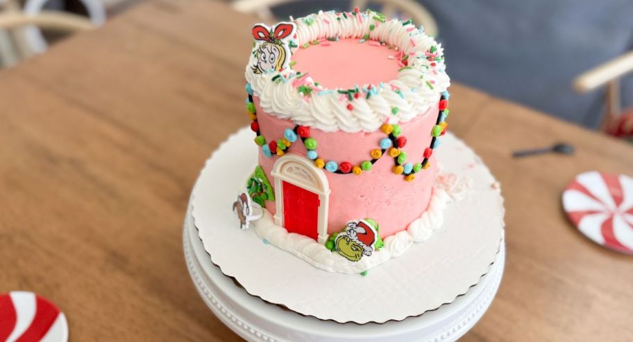 Grinch cake dispayed on top of the table next to other plates