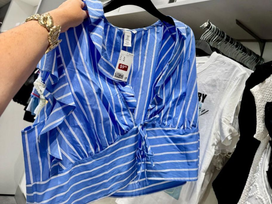 Hand holding an H&M clearance tank top on a hanger