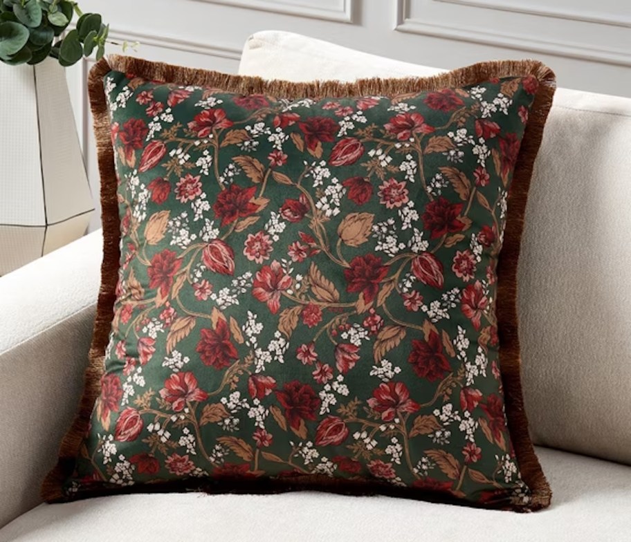 floral green and dark red pillow on beige couch