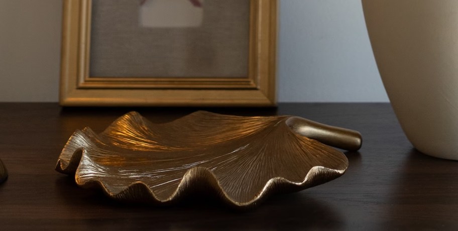 Gold trinket dish on wood console table 