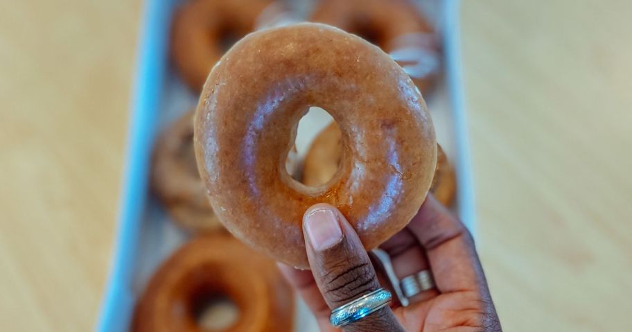 Hand Holding a Krispy Kreme Pumpkin SPice Original Glazed Doughtnut