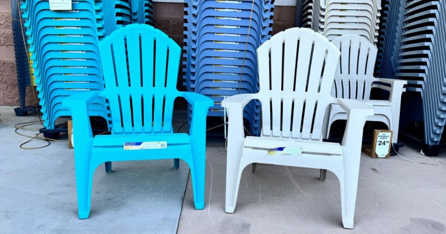 Two plastic Adirondack chairs at Lowe's in front of rows of stacked chairs