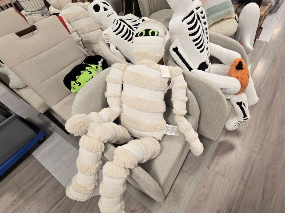 A life-sized mummy pillow on a chair in a store