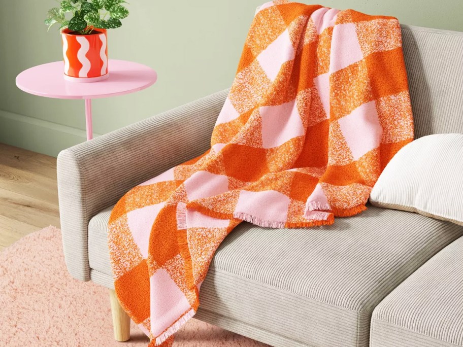 orange and pink check throw blanket on a couch