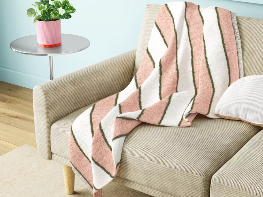 pink, white, and green striped throw blanket on a couch