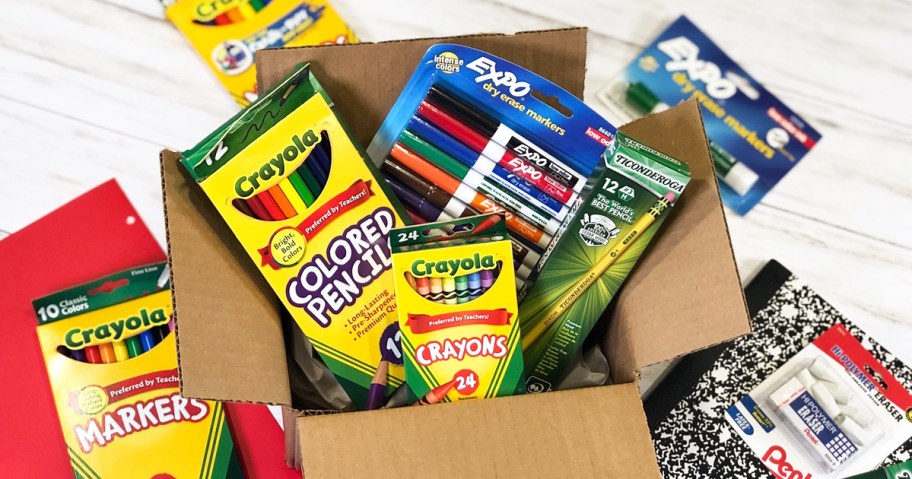 various school supplies in and around a cardboard box