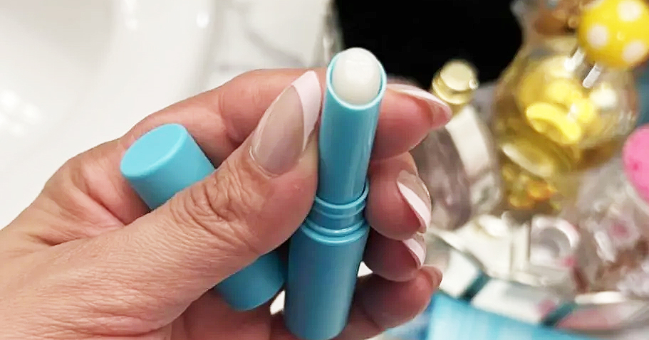 person holding a caffeine eye stick in a teal tube