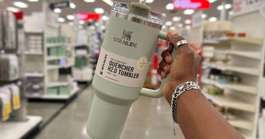hand holding a light green stanley tumbler