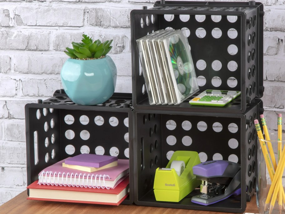 stacked black mini crates with office supplies in them