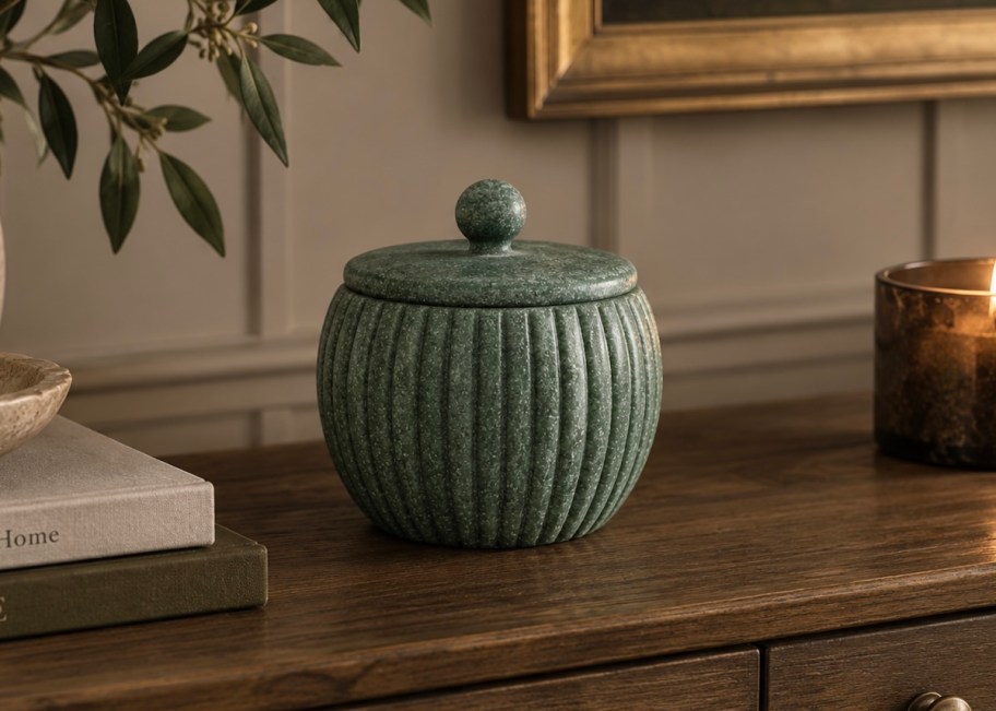 green marble lidded jar on wood table