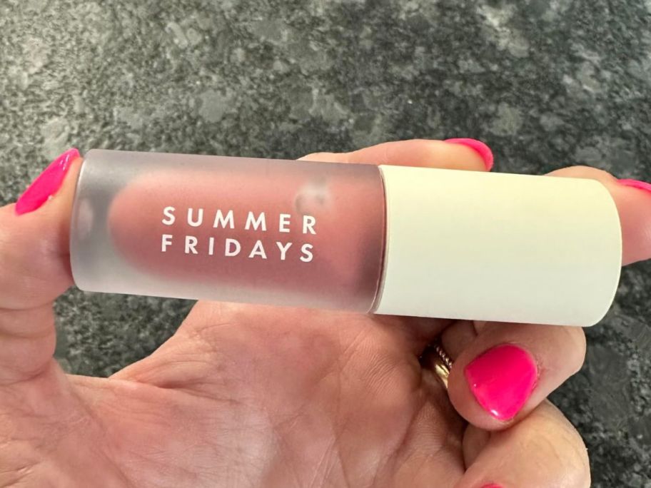 Hand holding a Summer Fridays Dream Lip Oil