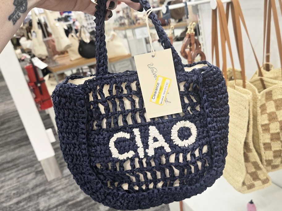 hand holding a blue crochet bag that says ciao