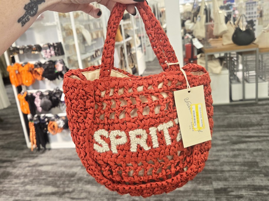 hand holding a red crochet bag that says spritz